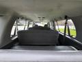 Interior view of a 2004 Ford Econoline showing rows of gray seating with seatbelts visible and a spacious cabin design