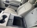 Interior of a 2017 Ford F-550 showing gray fabric seats and a central console with storage and cup holders