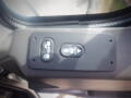 Close-up of a control panel featuring buttons labeled for door operation and automatic functions in a vehicle