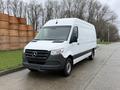 A 2019 Mercedes-Benz Sprinter van in white with a black front grille and wheels parked on a street
