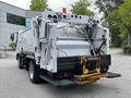 A 2014 Hino 195 garbage truck with a rear-loading mechanism and visible hydraulic components