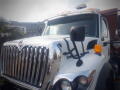 A white 2016 International WorkStar 7500 truck with a prominent grille and side mirror is prominently displayed in the foreground