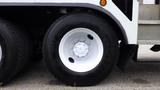 A white wheel with a circular hub and black tire from a 2012 International 7400 truck