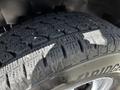 Close-up of a Bridgestone tire with a textured tread pattern mounted on a wheel of a 2013 Chevrolet Express