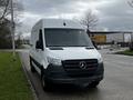 A 2021 Mercedes-Benz Sprinter van with a white exterior and black grille positioned on a road