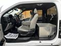 A 2016 Ford F-150 interior showing a spacious front seat with light gray upholstery and a diamond plate tool chest positioned in the passenger area