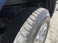 Close-up of a tire mounted on a 2015 Ford F-150 showing tread patterns and chrome wheel rim