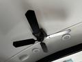 Ceiling fan with three black blades and a central motor in a recreational vehicle