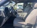 Interior view of a 2017 Ford F-150 showing front seats with gray fabric upholstery and a dashboard featuring gauges and controls