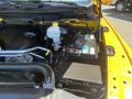Close-up of the engine compartment of a 2015 RAM 1500 showing the battery coolant reservoir and various engine components