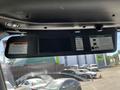 The interior dashboard area of a 2022 Freightliner Cascadia featuring a display screen and various warning and notice labels attached