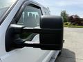 A close-up of the side mirror of a white 2008 Ford F-250 Super Duty truck