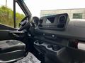 Interior view of a 2023 Mercedes-Benz Sprinter showcasing the dashboard with a touchscreen display and cup holders