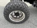 Close-up of a large, rugged tire mounted on a wheel from a 2012 Toro Groundsmaster 5910 with pronounced tread patterns and visible wear