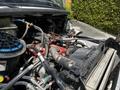 Close-up of the engine components of a 2010 Freightliner M2 106 showing various pipes wires and connectors with a blue air filter element visible