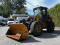 A 2010 John Deere 444K front loader with large tires and a bucket attachment positioned at the front