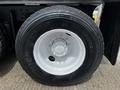 Close-up of a black tire mounted on a white rim from a 2017 International WorkStar 7600 showing the tread and valve stem