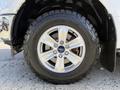 A close-up of a silver alloy wheel with a Ford logo and an all-terrain tire on a 2018 Ford F-150