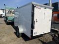 A white 2020 Mirage Enterprises 12 Foot Cargo trailer with a double rear door and silver wheels parked beside another trailer