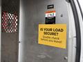 2022 GMC Savana with a yellow warning sign that reads IS YOUR LOAD SECURE Double check before you leave
