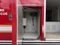 A red 2007 Ford F-550 with a compartment door open revealing storage space and equipment mounted inside