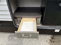 A partially open drawer in a 2021 Jayco Jay Flight camper with a light wooden interior and a dark exterior handle