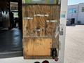 A wooden door panel with metal clasps attached to the rear of a 2009 Morgan Olson Workhorse vehicle