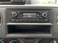 The interior dashboard of a 2021 Ford E-450 featuring a radio control panel with buttons and a digital display showing the date and time