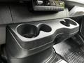 Close-up of the interior console of a 2020 Mercedes-Benz Sprinter featuring a black plastic cup holder with three compartments