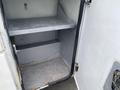 A 2003 Ford F-450 SD with an open storage compartment featuring two metal shelves and a gray interior showing signs of wear and rust