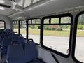 Interior of a 2017 Chevrolet Express with blue fabric seats and large windows providing a view outside