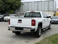 White 2016 GMC Sierra 1500 pickup truck with a chrome rear bumper and GMC logo prominently displayed on the tailgate