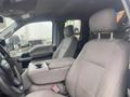 Interior of a 2017 Ford F-550 showing driver and passenger seats with a central armrest and cup holder