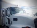 A 2021 Mack MD truck with a white exterior and orange cab lights, featuring large side mirrors and a prominent front grille