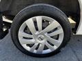 A close-up of the front wheel of a 2017 Nissan NV200 featuring a silver alloy rim and a black tire with tread visible