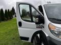 A white 2016 RAM Promaster van with the driver's door open showcasing its side mirror and part of the interior