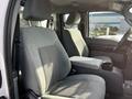 Interior view of a 2011 Ford F-450 SD showing two front seats with gray fabric upholstery and a center console between them
