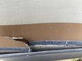 A damaged section of the side of a 1987 Chevrolet Fleetwood Pace Arrow showing exposed layers of material and a jagged edge