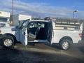 A 2013 Ford F-150 with an open passenger door and a truck bed that has a metal cap and tool storage compartments