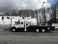 A 2008 International 7500 utility truck with an extended flatbed and a mounted crane on one side designed for lifting and utility work