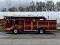 A red 2009 Spartan Gladiator fire truck with a ladder on top and multiple compartments on the side