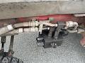 A close-up view of hydraulic hoses and a black hydraulic valve block connected to a Toro Groundsmaster 5910 mower