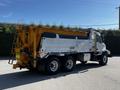 2005 Volvo VND 122 dump truck with a metal bed and yellow rear dumping mechanism visible from the side