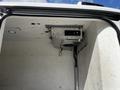 Interior of a 2015 Ford Transit showing a ceiling-mounted refrigeration unit with exposed wiring and a damaged surface