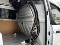 A 2016 Ford Transit Connect interior with exposed wiring and components including hoses and a storage area