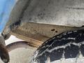 A close-up view of a 2006 Ford Econoline showing a weathered underside with rust and a textured tire tread