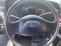 Steering wheel of a 2012 Ford Econoline featuring the Ford logo and instrument panel with gauges and controls visible