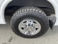 Close-up of a chrome wheel rim with a rugged tire on a 2012 GMC Savana showing detailed tread patterns and a shiny finish