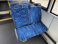 Two blue bus seats with a white abstract pattern designed for a public transit vehicle