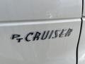 A close-up of the chrome emblem on a 2005 Chrysler PT Cruiser showing the letters PT CRUISER